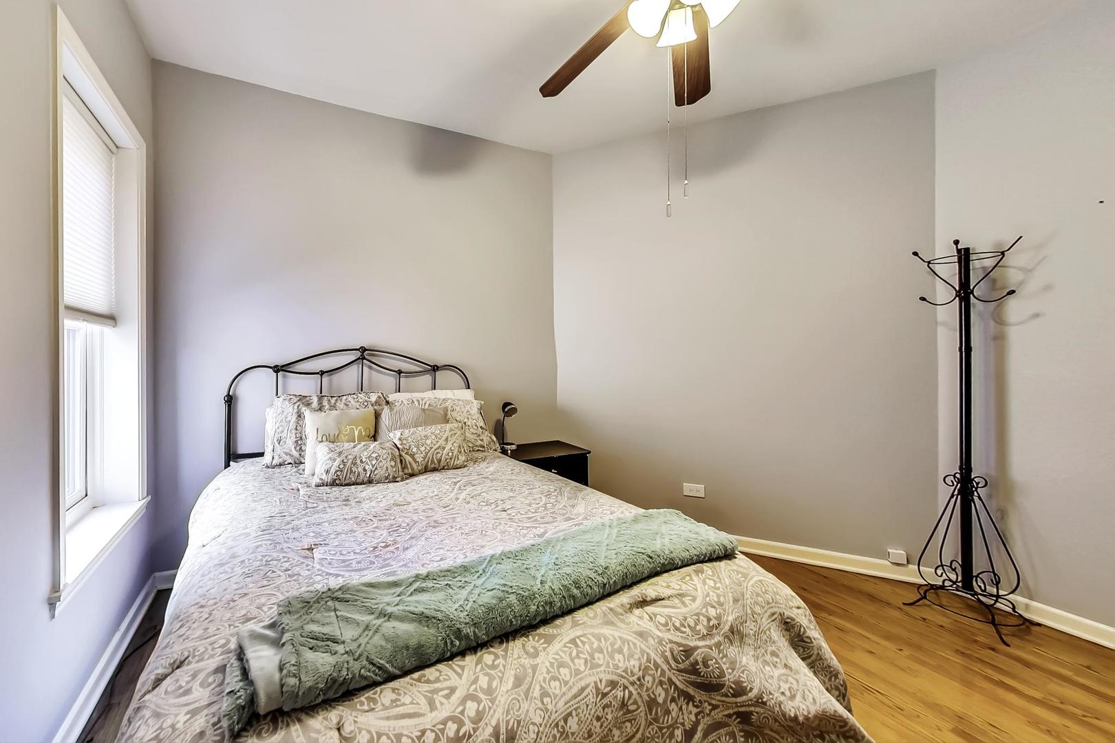 4214 North Kenmore Avenue, Unit 2F Chicago, IL 60613 - Photo 22 of 23 a bedroom with a bed and a chandelier