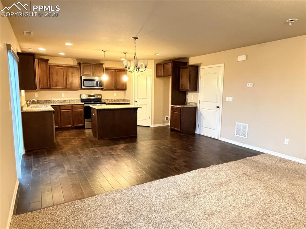11605 Avena Road Peyton, CO 80831 - Photo 5 of 13 a large kitchen with a large counter top a sink stainless steel appliances and cabinets