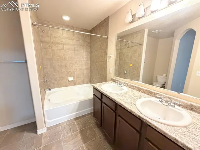 a bathroom with a granite countertop sink a mirror a bathtub and shower