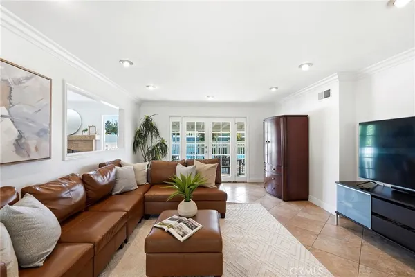 a living room with furniture kitchen view and a large window