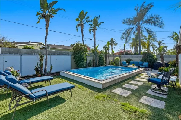a living room with furniture a rug potted plant and a mirror