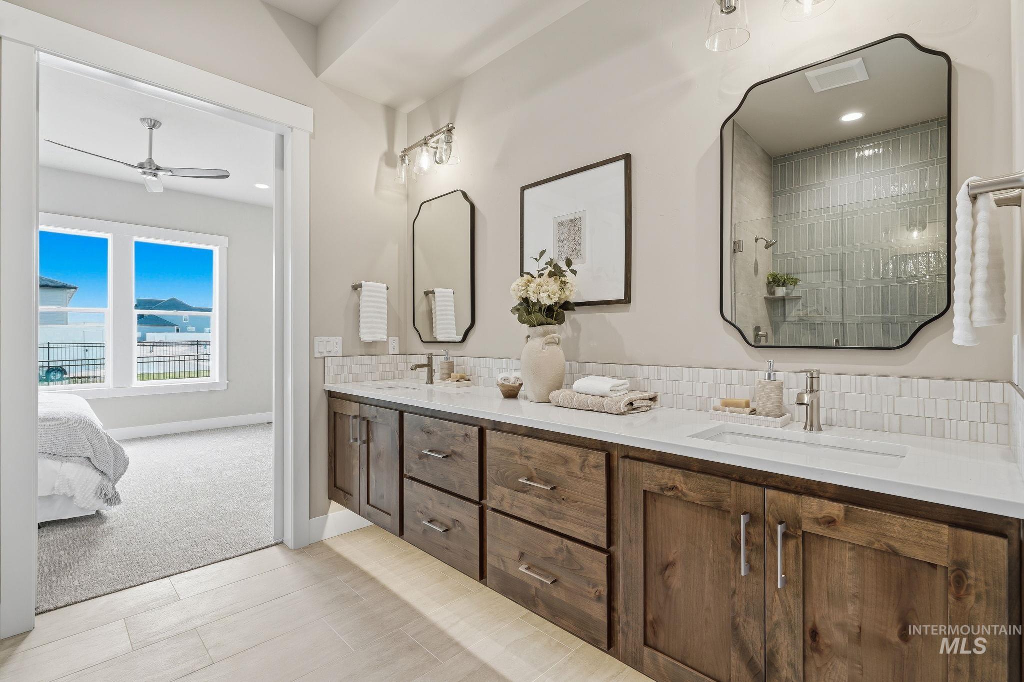 470 South Radiator Way Boise, ID 83716 - Photo 47 of 50 Dual wood-finish vanities with undermount sinks, white countertops, and brushed nickel fixtures