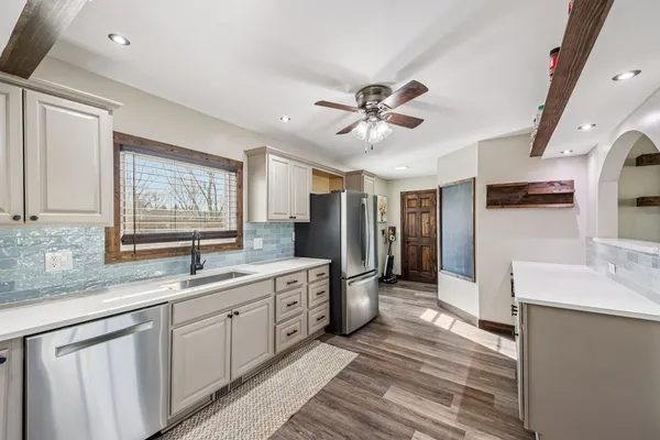 a large white kitchen with a large window
