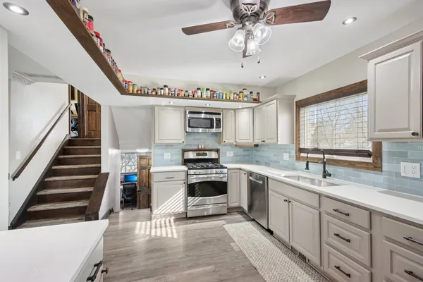 a kitchen with cabinets a sink and appliances