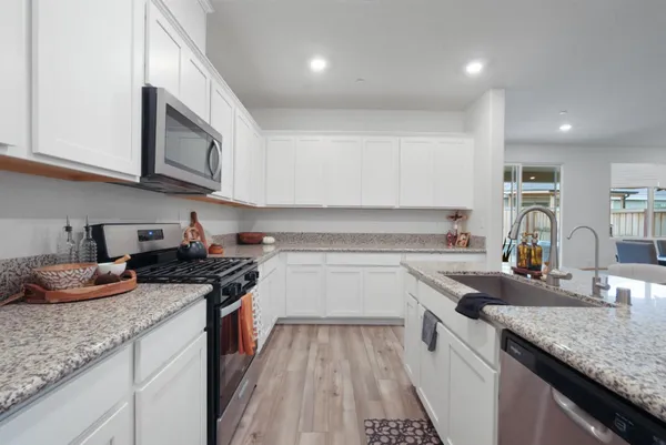 a kitchen with stainless steel appliances granite countertop a sink stove and cabinets