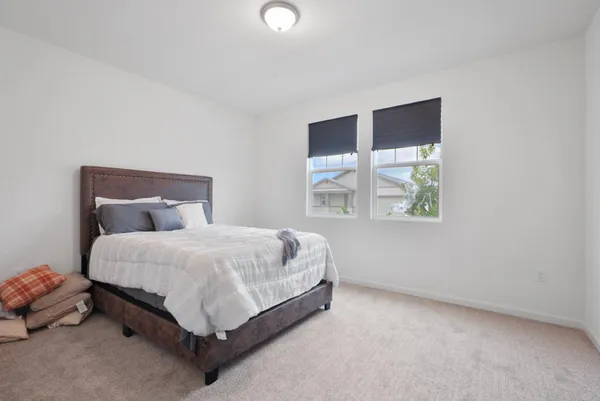 a bed sitting in a bedroom next to a window