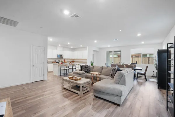 a living room with furniture and a wooden floor