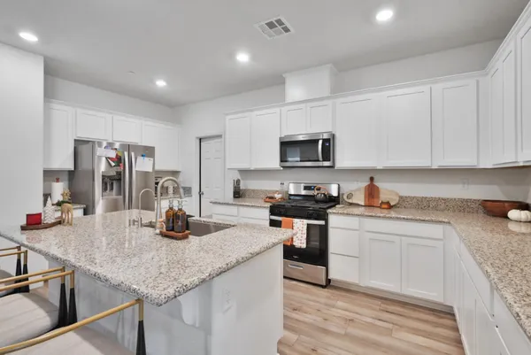 a kitchen with sink a stove and cabinets