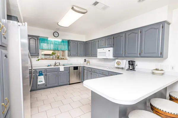 a kitchen with a sink a stove a refrigerator and cabinets