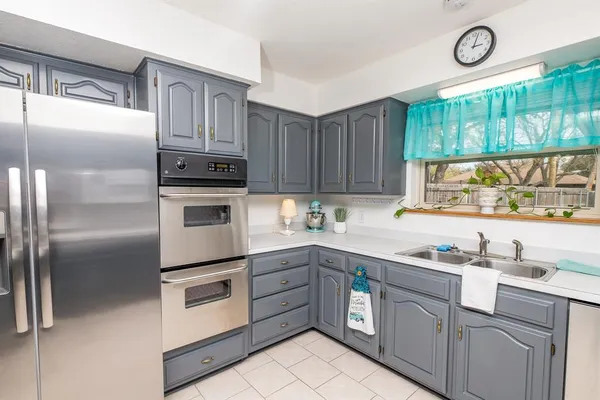 a kitchen with cabinets stainless steel appliances and a window