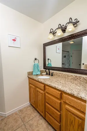 a bathroom with a granite countertop sink and a mirror