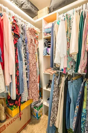 a view of walk in closet with clothes