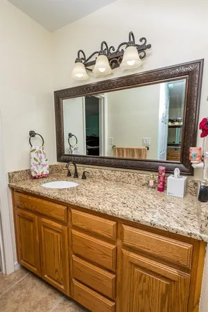 a bathroom with a granite countertop sink and a mirror