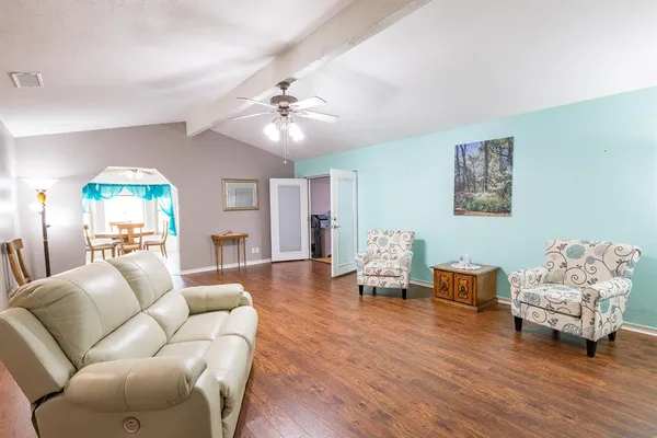 a living room with furniture and a wooden floor