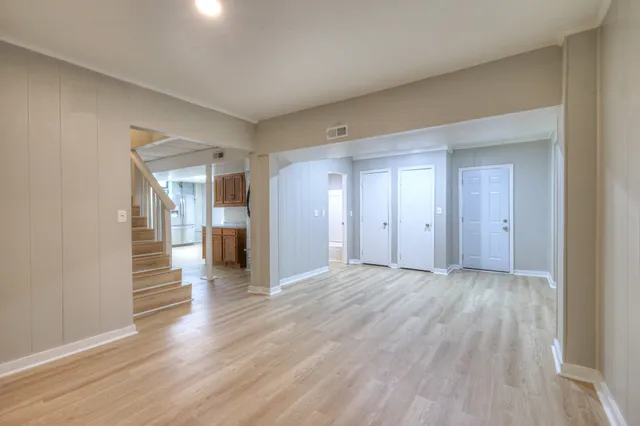 a view of a big room with wooden floor and a kitchen