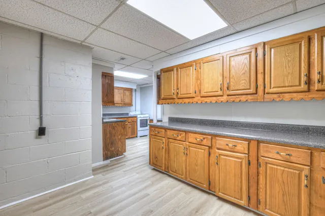 a kitchen with cabinets and wooden floor
