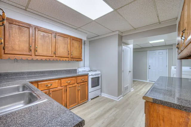 a kitchen with a sink cabinets and wooden floor