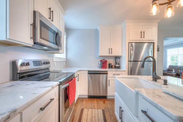 a kitchen with stainless steel appliances granite countertop a sink stove and refrigerator