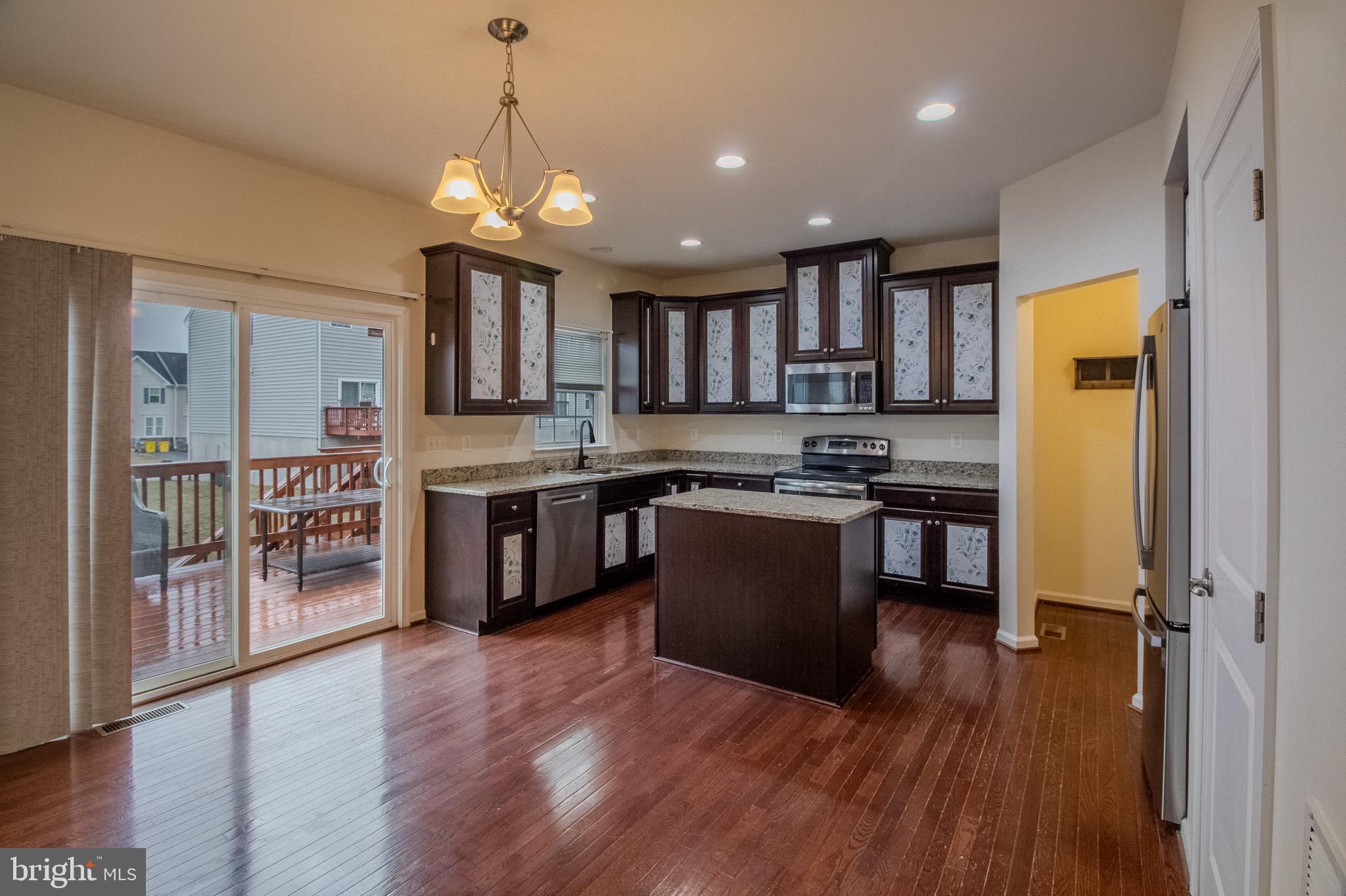 57 Tollerton Trail Falling Waters, WV 25419 - Photo 12 of 59 a kitchen with stainless steel appliances granite countertop wooden floors and sink