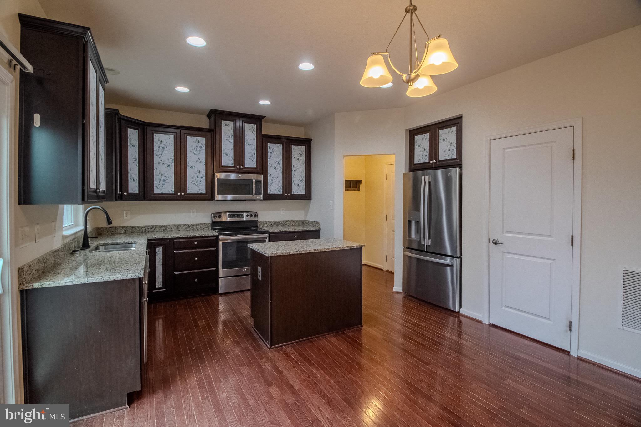 57 Tollerton Trail Falling Waters, WV 25419 - Photo 13 of 59 a kitchen with granite countertop a refrigerator stove and sink