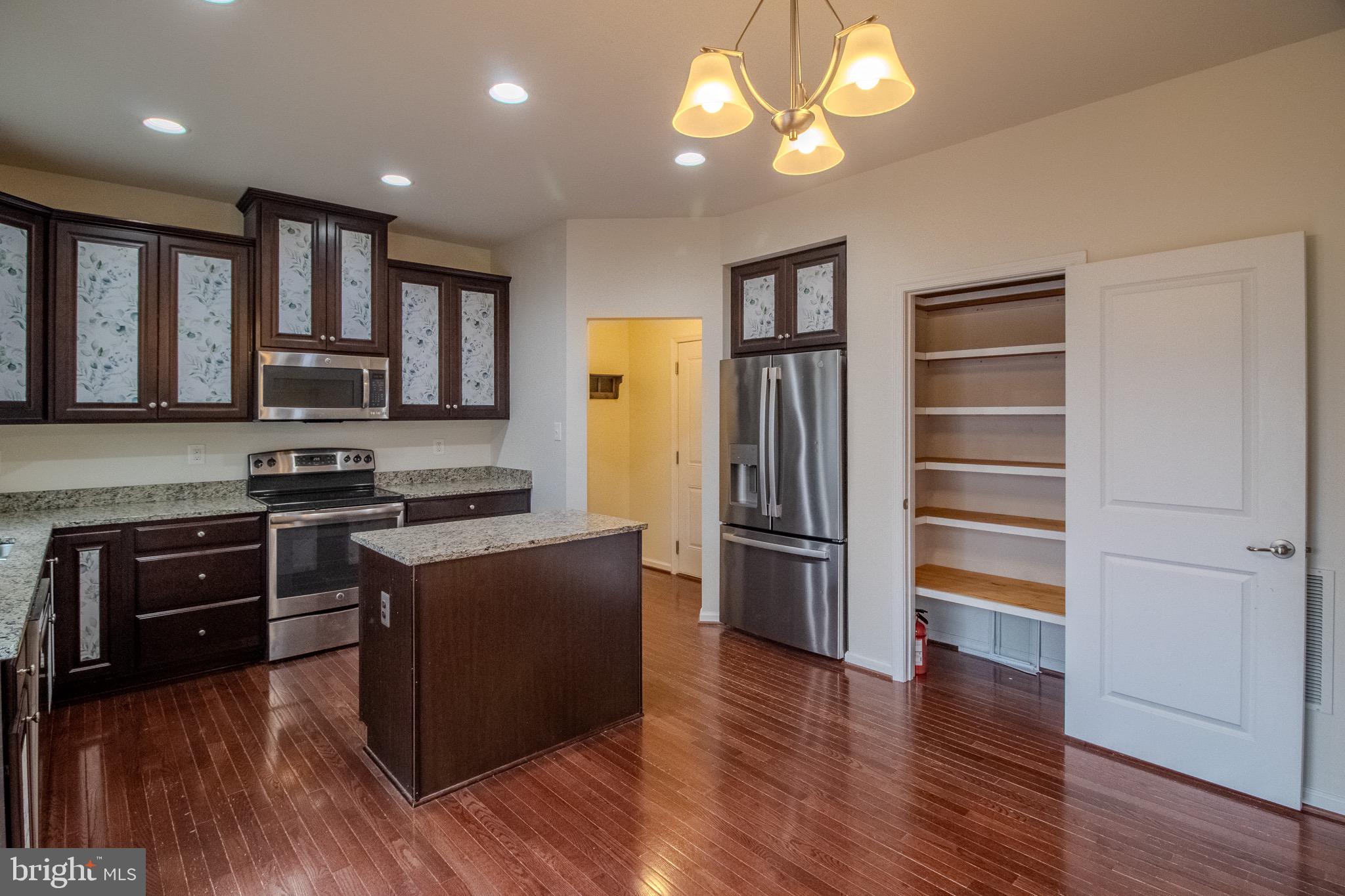 57 Tollerton Trail Falling Waters, WV 25419 - Photo 14 of 59 a kitchen with stainless steel appliances granite countertop a refrigerator stove and oven with wooden floors