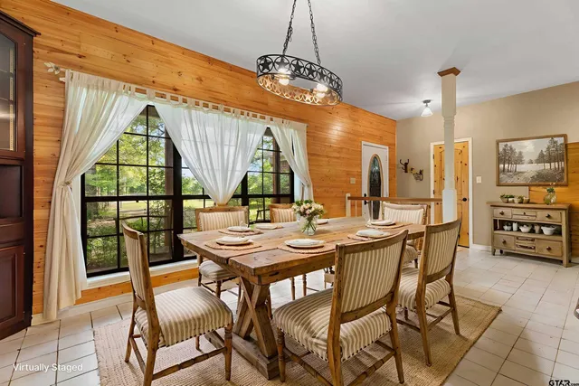 a dining room with furniture a chandelier and wooden floor