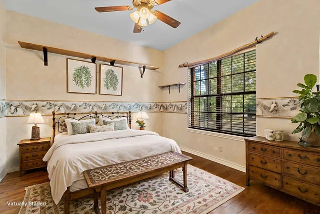 a bedroom with a bed a dresser and next to a window