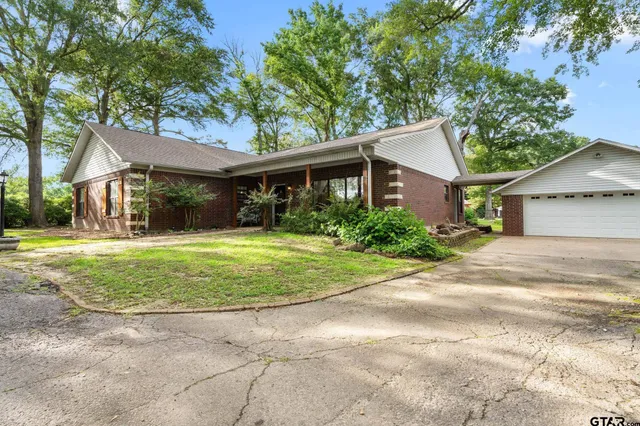 a front view of a house with a yard and potted plants