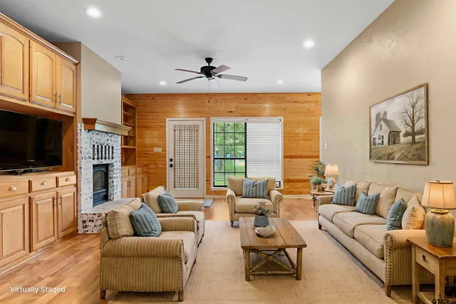 a living room with furniture ceiling fan and a flat screen tv