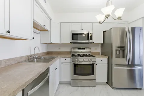 a kitchen with stainless steel appliances granite countertop a refrigerator a stove top oven a sink and dishwasher