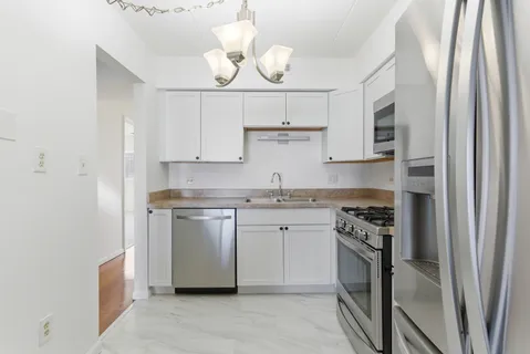 a kitchen with stainless steel appliances granite countertop a stove a sink and a refrigerator