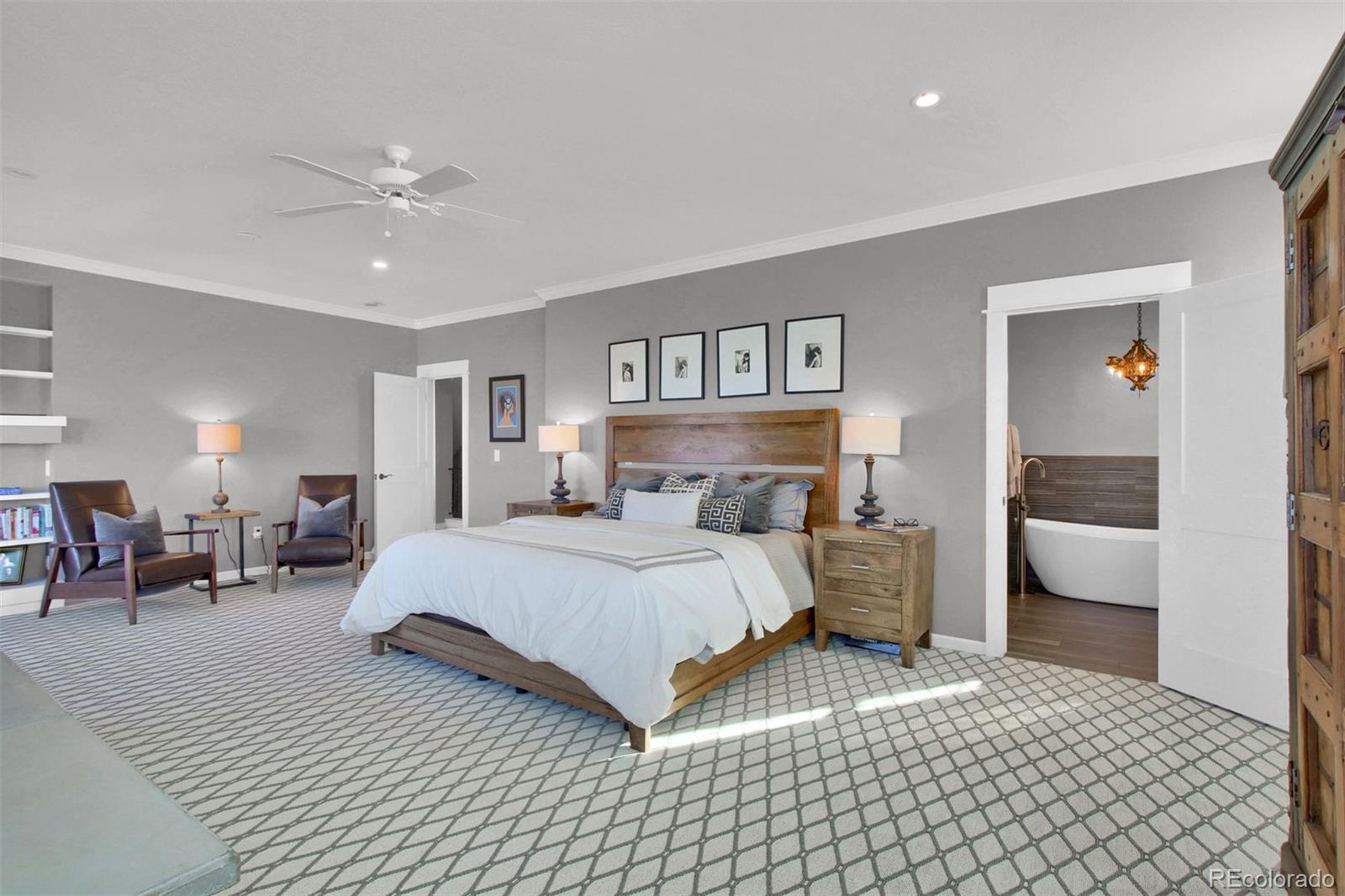 2940 Canon Ridge Road Castle Rock, CO 80104 - Photo 23 of 49 a bedroom with a large bed and a chandelier