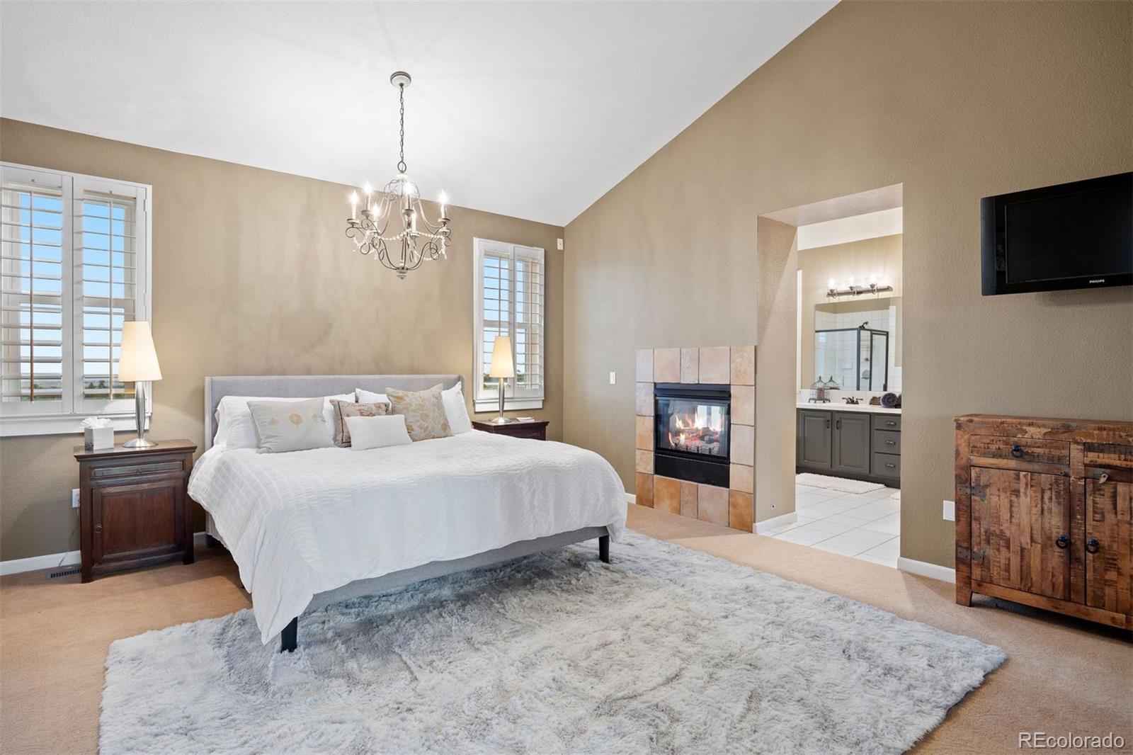 2940 Canon Ridge Road Castle Rock, CO 80104 - Photo 26 of 49 a spacious bedroom with a large bed and a flat screen tv