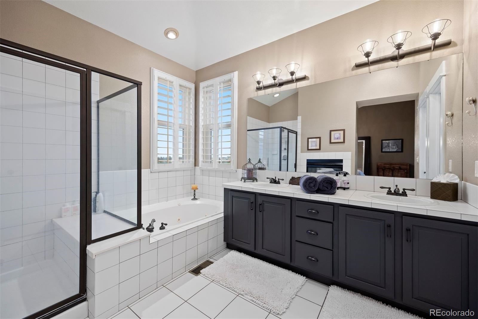 2940 Canon Ridge Road Castle Rock, CO 80104 - Photo 27 of 49 a spacious bathroom with a double vanity sink a large mirror and a bathtub