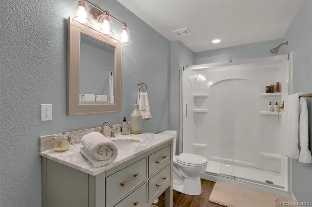 a bathroom with a sink toilet double vanity and shower