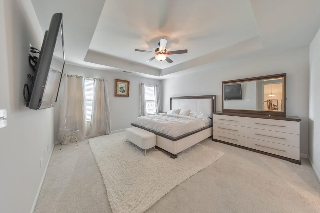 3146 Dowsing Lane Powder Springs, GA 30127 - Photo 18 of 42 a spacious bedroom with a bed and a chandelier