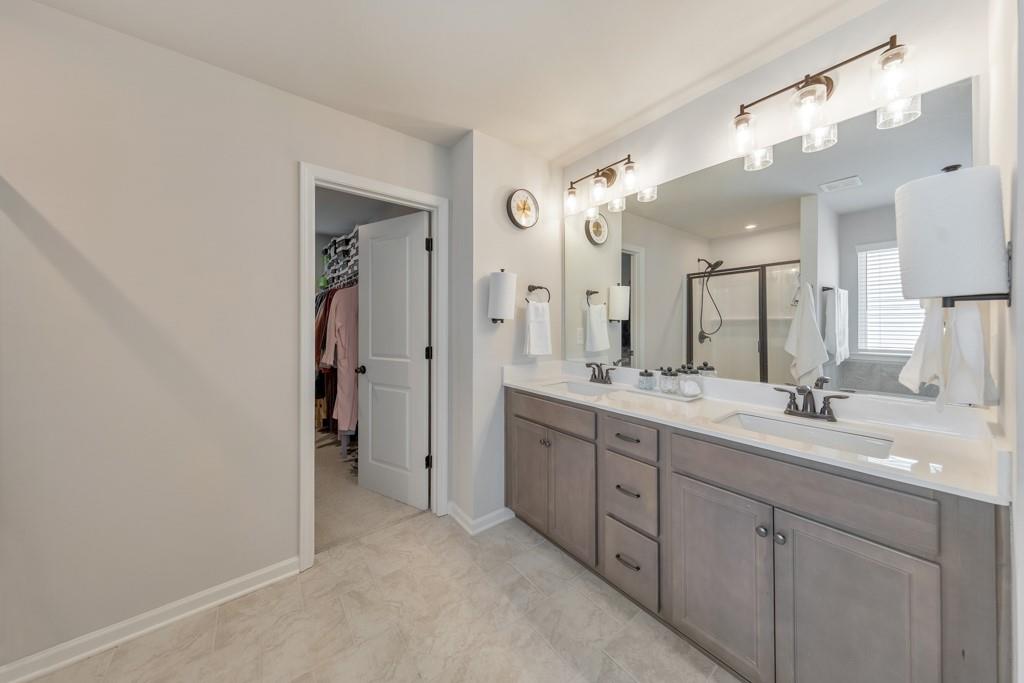 3146 Dowsing Lane Powder Springs, GA 30127 - Photo 21 of 42 a spacious bathroom with a double vanity sink shower and a mirror