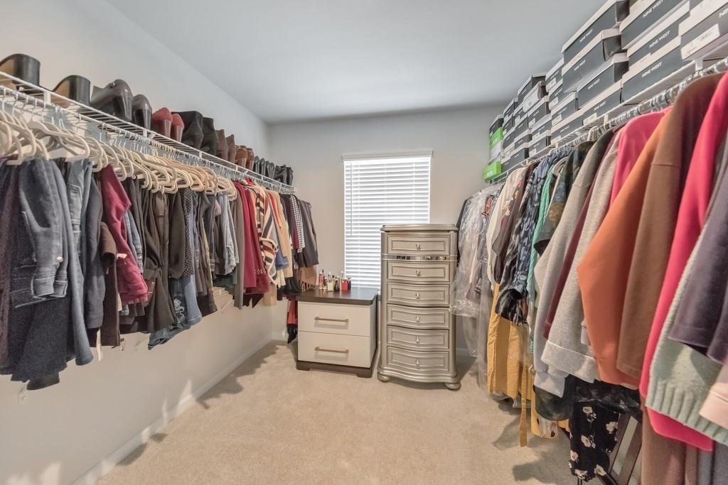 3146 Dowsing Lane Powder Springs, GA 30127 - Photo 23 of 42 a view of walk in closet with clothes and shoes