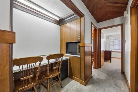 a view of a hallway and an dining rom with furniture