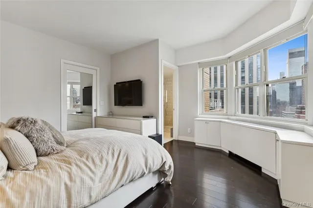 a bedroom with a large bed and a flat tv screen on a dresser