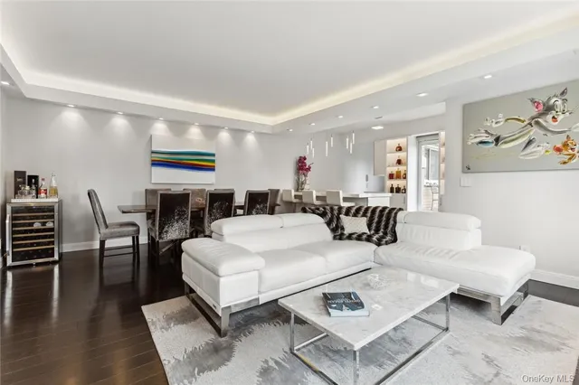 a living room with furniture a rug and kitchen view