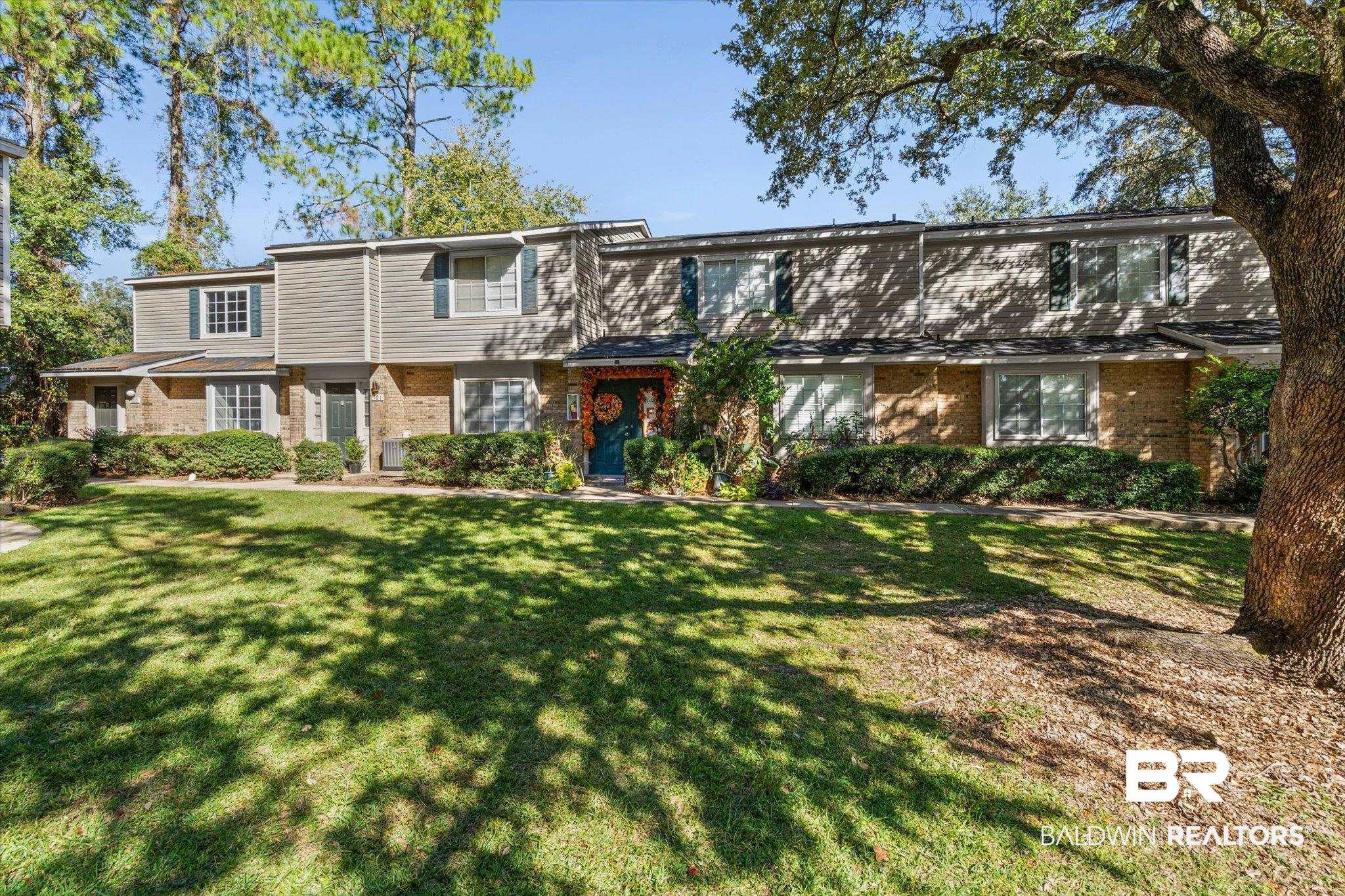 6701 Dickens Ferry Road, Unit 100 Mobile, AL 36608 - Photo 21 of 24 View of front facade with brick siding and a front lawn