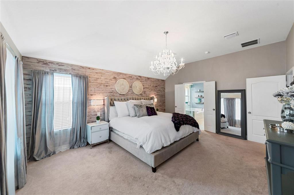 1551 Crystal Pass Allen, TX 75002 - Photo 13 of 27 a spacious bedroom with a bed and chandelier