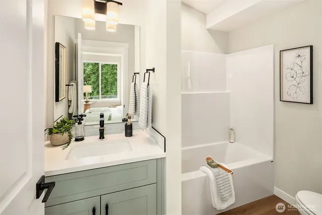 a bathroom with a sink a bathtub and a window