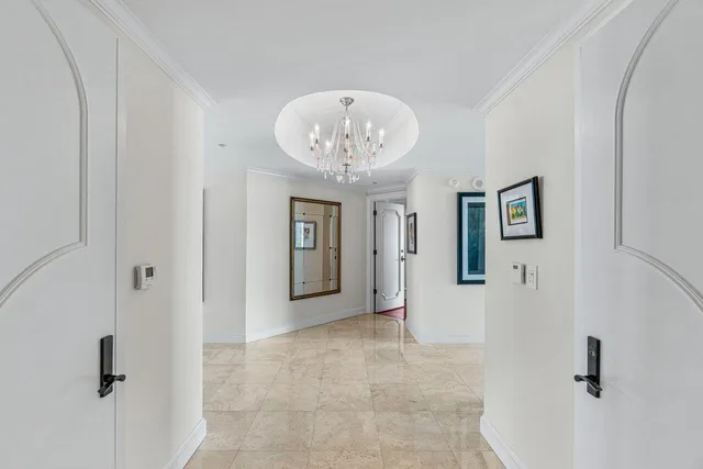 a view of a hallway with windows and chandelier