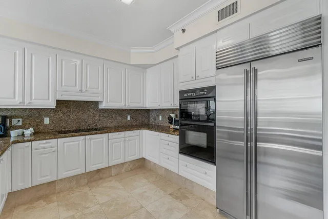 a kitchen with granite countertop white cabinets and stainless steel appliances
