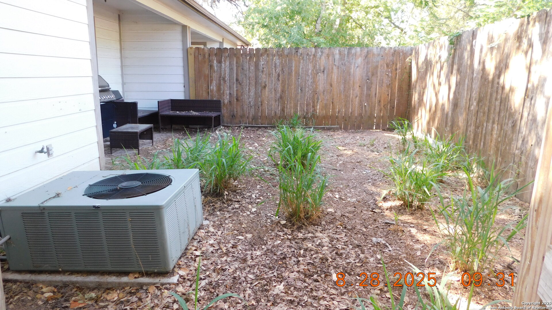 1411 Martin Street Pleasanton, TX 78064 - Photo 4 of 7 a backyard of a house with chairs and a fire pit