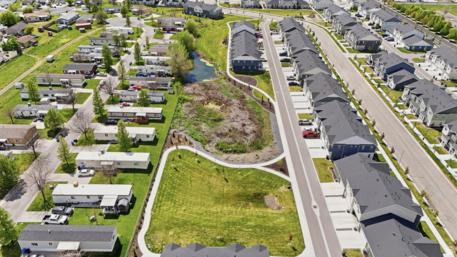 1173 West 1870 South Logan, UT 84321 - Photo 33 of 33 Aerial perspective showcasing a developed residential street with multiple townhomes featuring dark roofs and light-colored siding