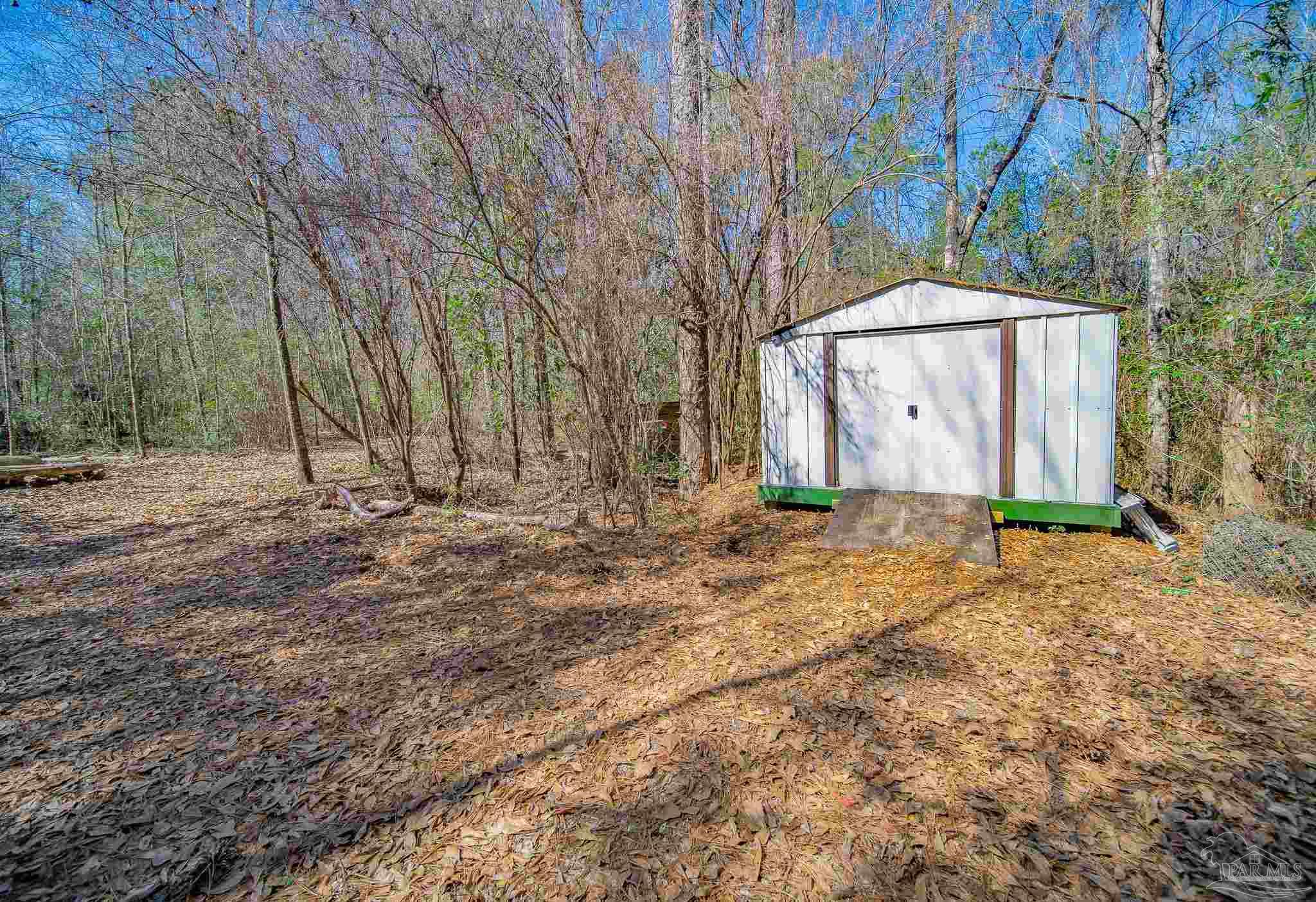 2800 Dunsford Road Jay, FL 32565 - Photo 35 of 42 a backyard of a house with large trees and a wooden fence