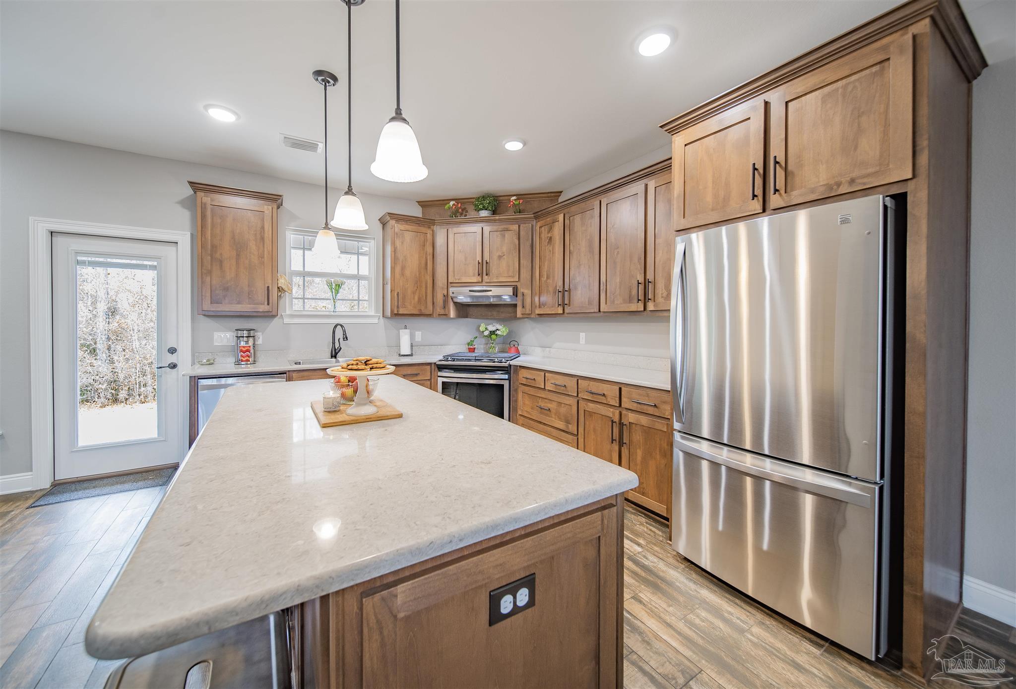 2800 Dunsford Road Jay, FL 32565 - Photo 8 of 42 a kitchen with stainless steel appliances granite countertop a refrigerator a sink dishwasher a stove and white cabinets with wooden floor
